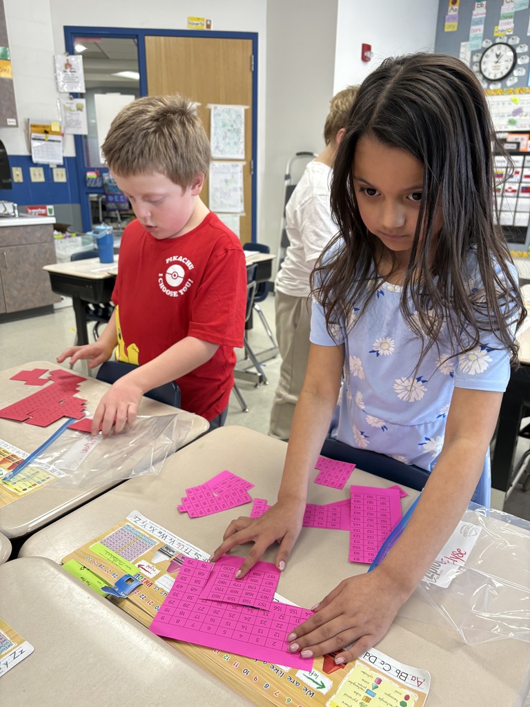 Students moving pieces around solving a puzzle.
