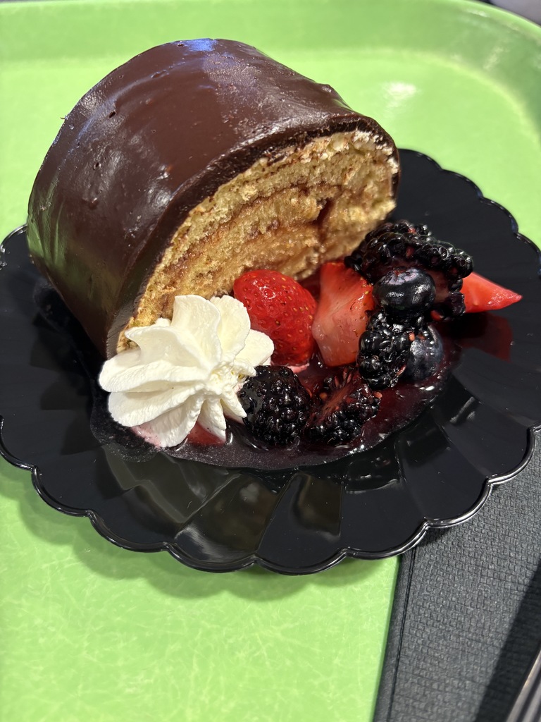 A fancy dessert on a plate with fresh fruit.