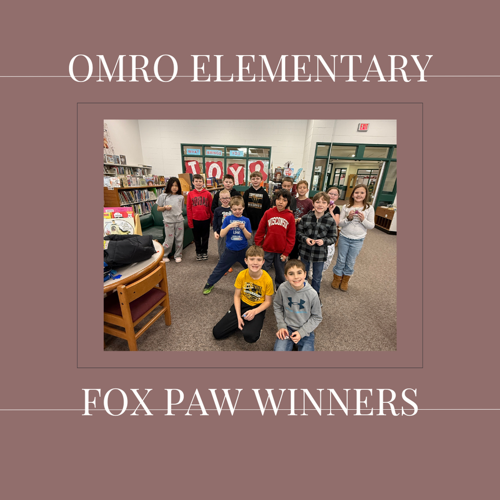A group of elementary students standing in a media center.