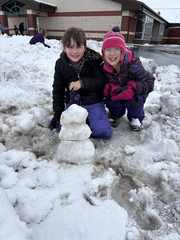Two elementary school students playing in the snow.