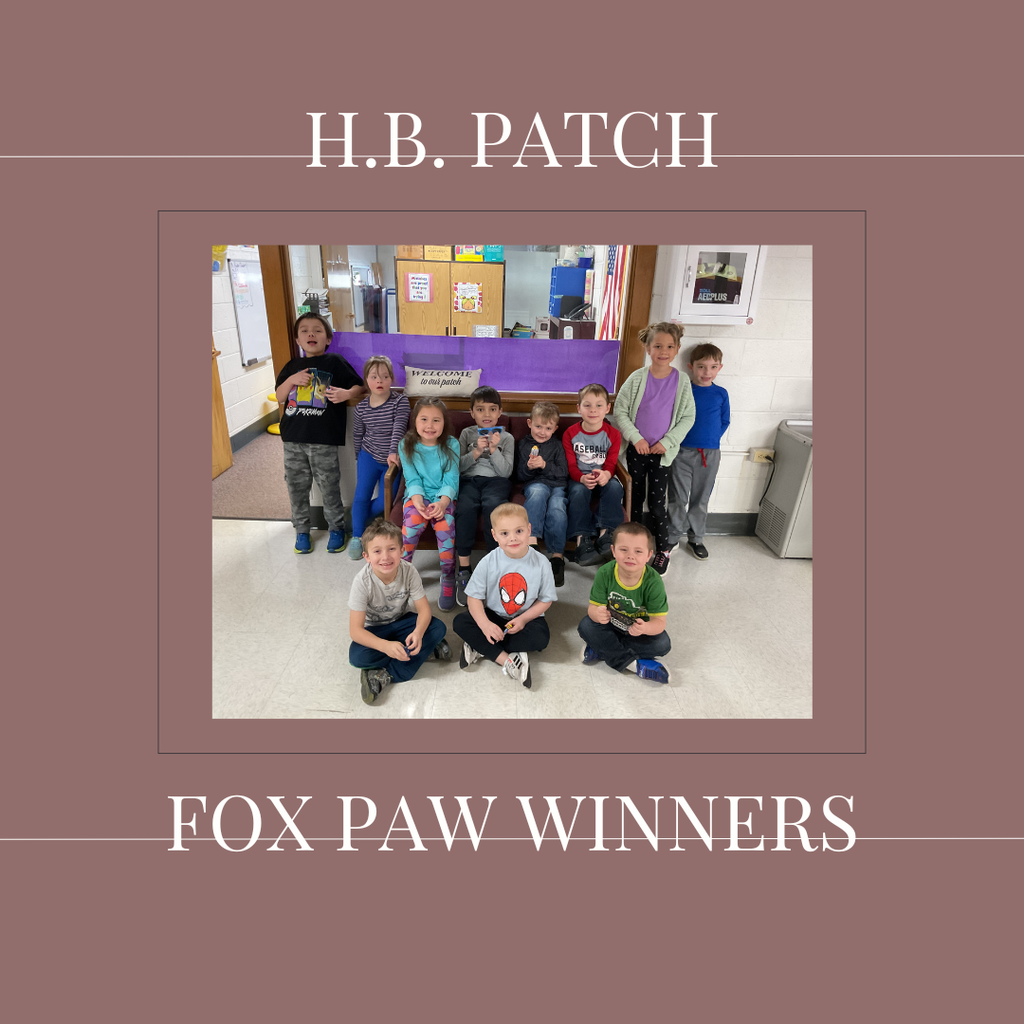 A group of early elementary students standing in front of a bulletin  board.