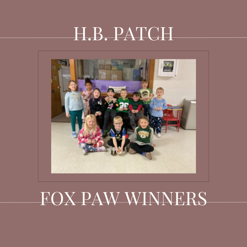A group of early elementary students standing in front of a bulletin  board.