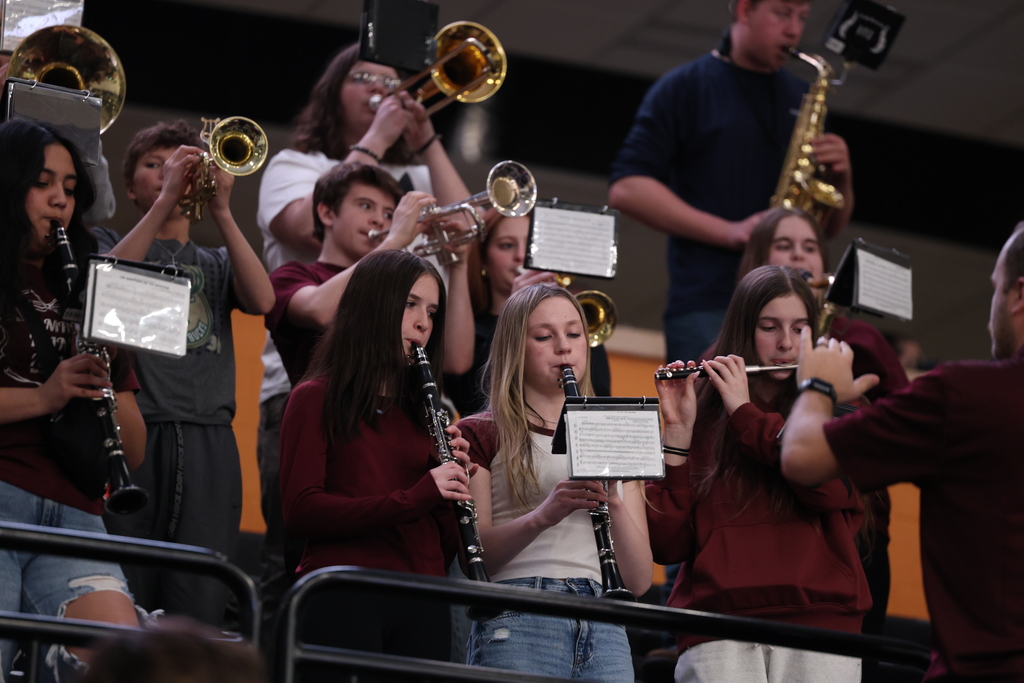High school students playing instruments in a pep band.
