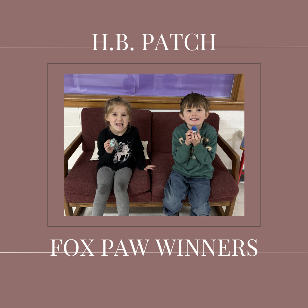 A couple of early elementary students standing in front of a bulletin board.