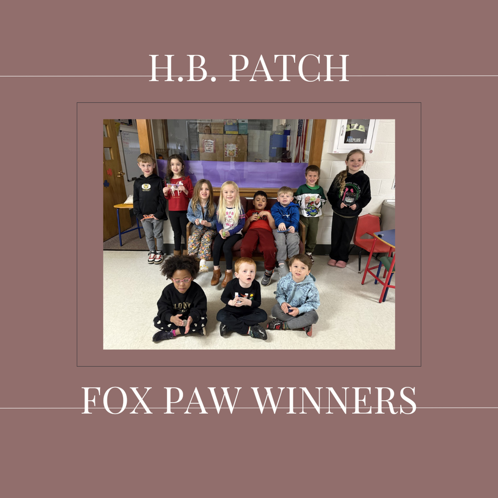 A group of early elementary students standing in front of a bulletin board.
