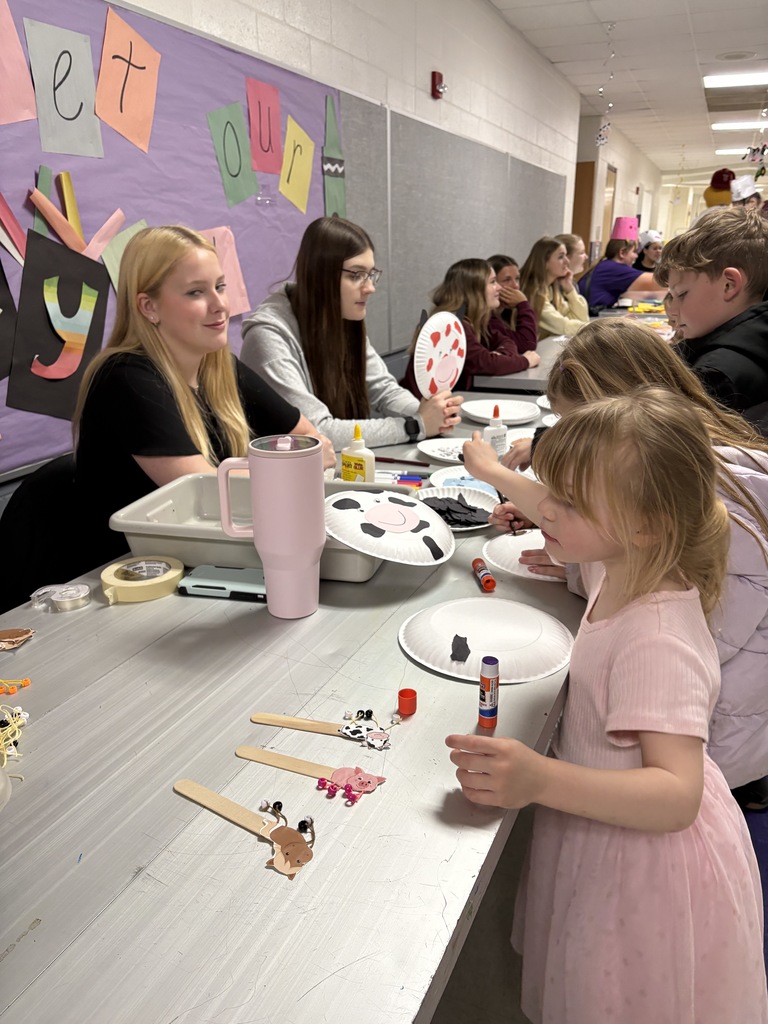 High school students helping young students with art projects.