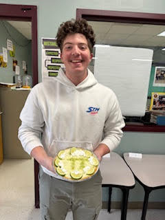 High school student holding a homemade pie.