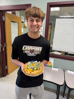 High school student holding a homemade pie.