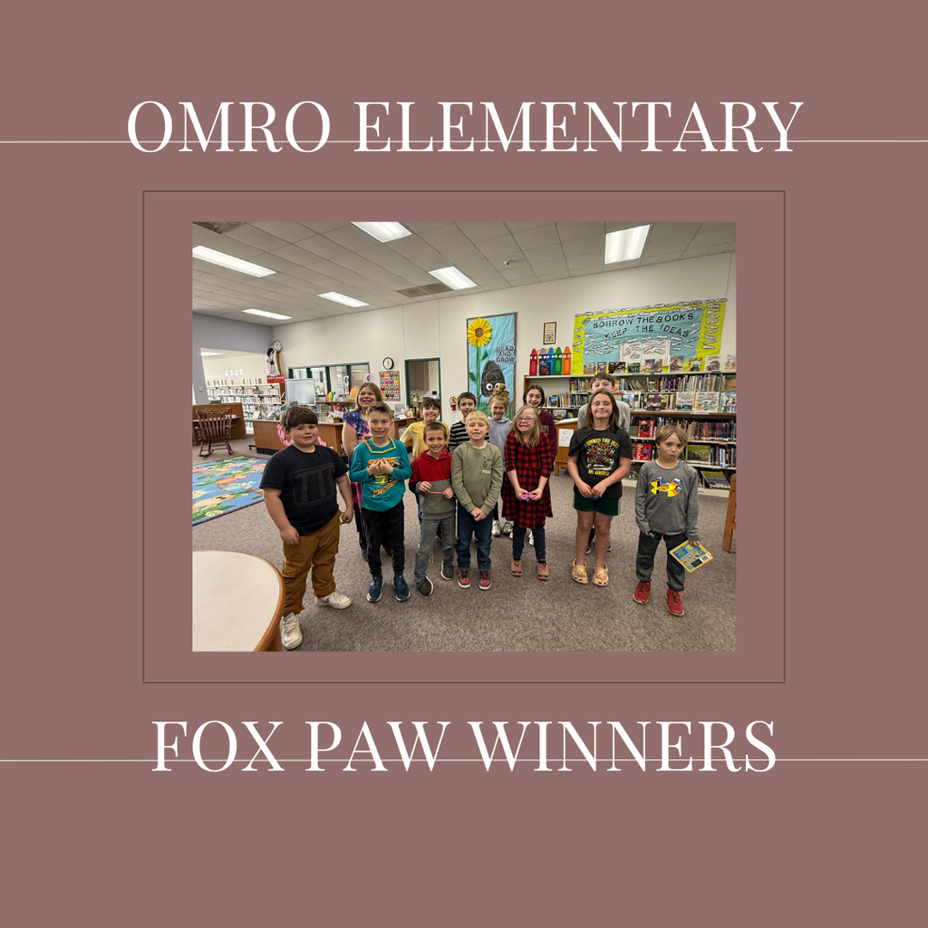 A group of elementary students standing in a media center.