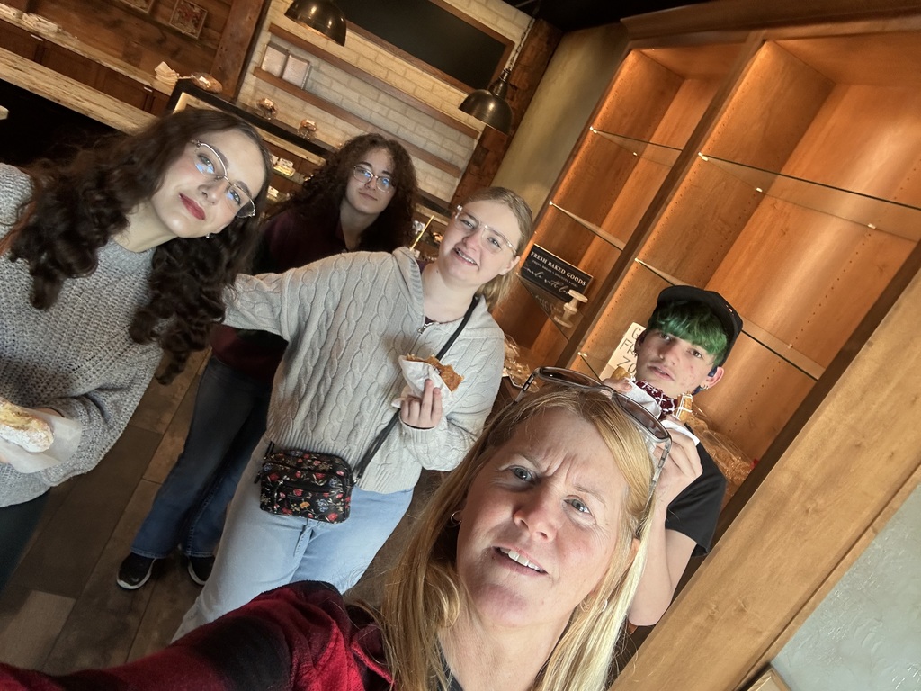A high school teacher and four students takign a selfie.