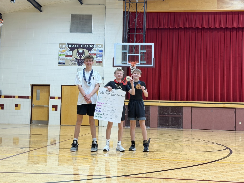 Three middle school students standing, holding a poster and a medal. 