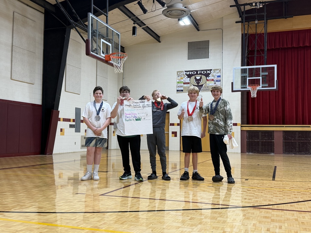 5 middle school students, standing, holding a poster and a medal. 