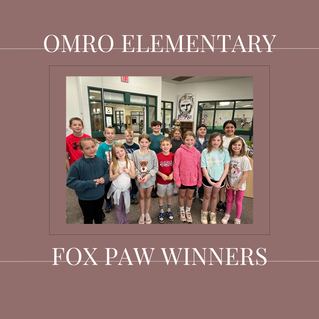 A group of elementary students standing in a media center.