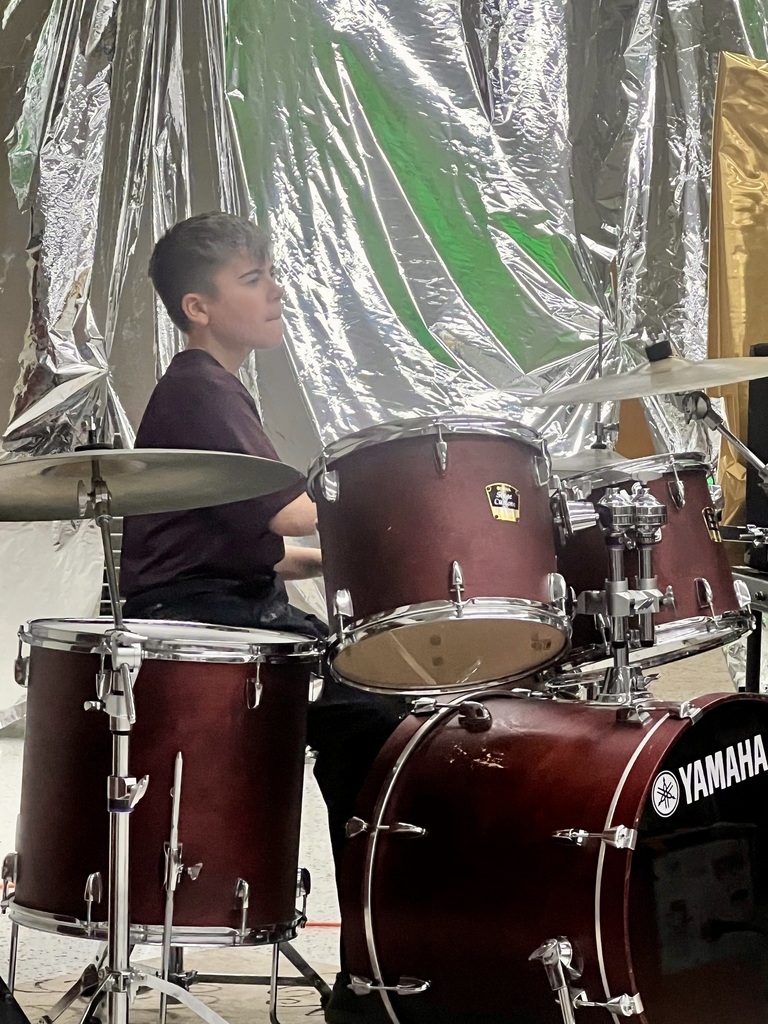 Middle school student playing the drums.
