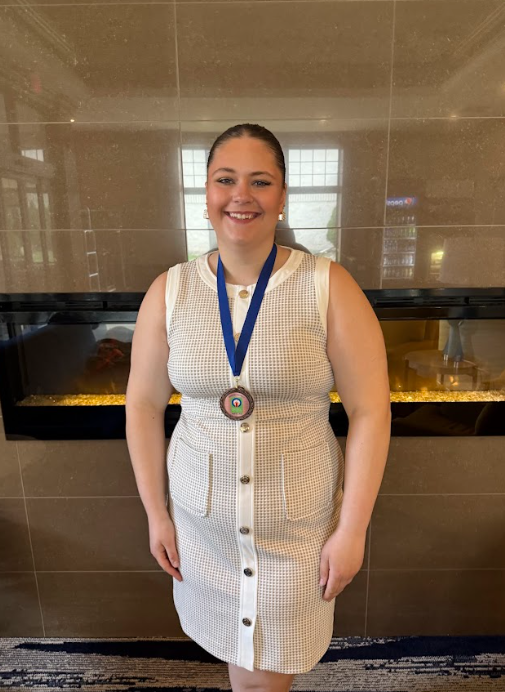 High school student standing with a medal around her neck.