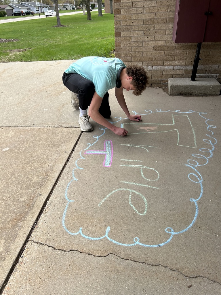High school student completing sidewalk art.