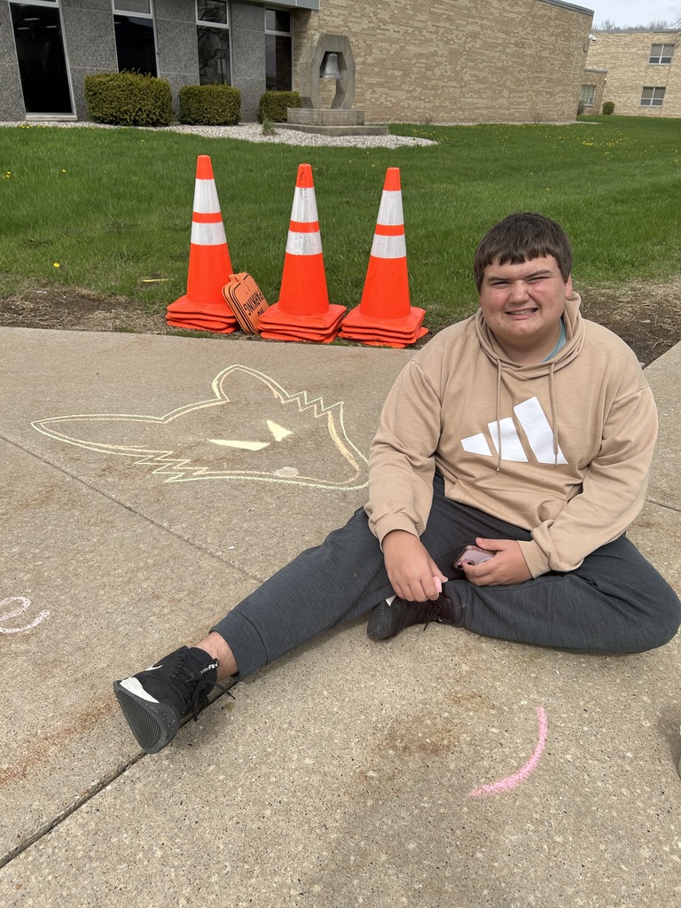 High school student doing sidewalk art with chalk. 