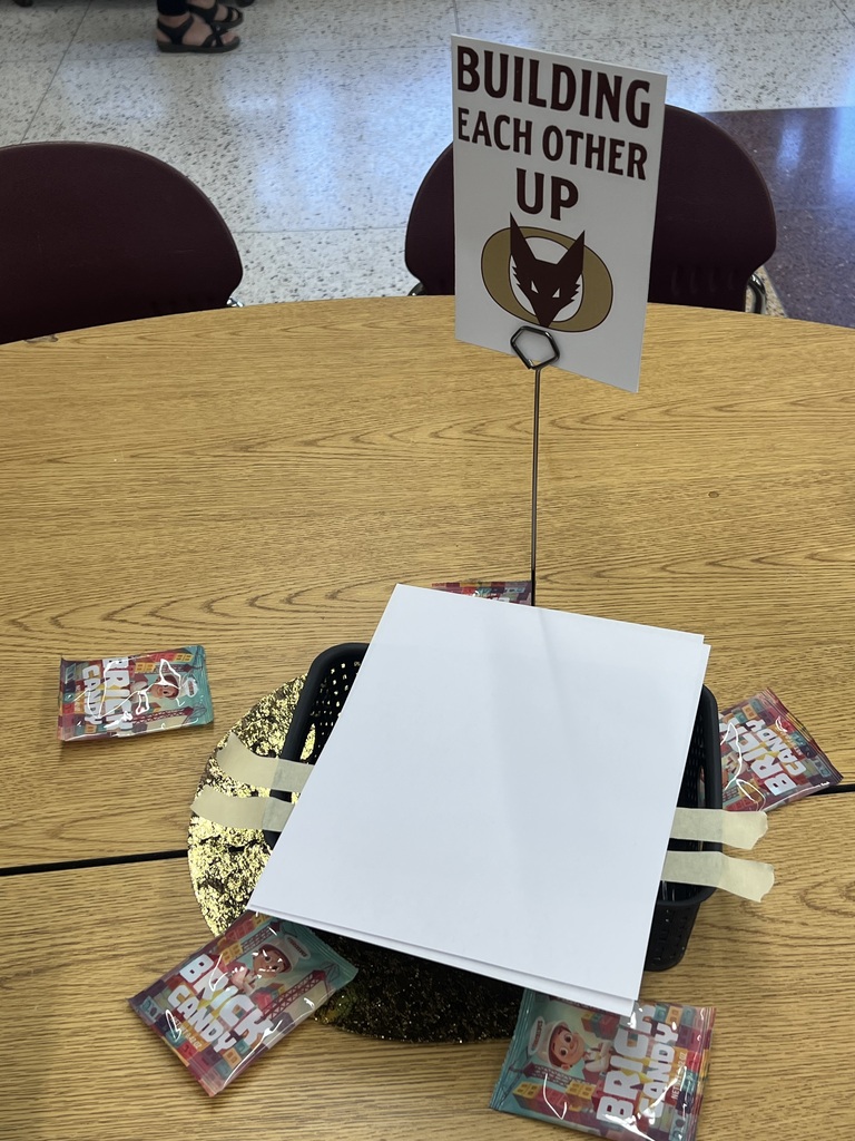 Table decor for a Welcome back event with a small sign that says "Building Each Other Up".