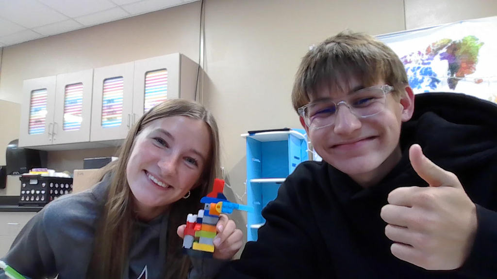 Two high school students displaying a lego build.