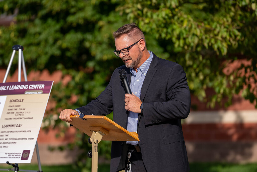 Superintendent speaking at a podium with a microphone.