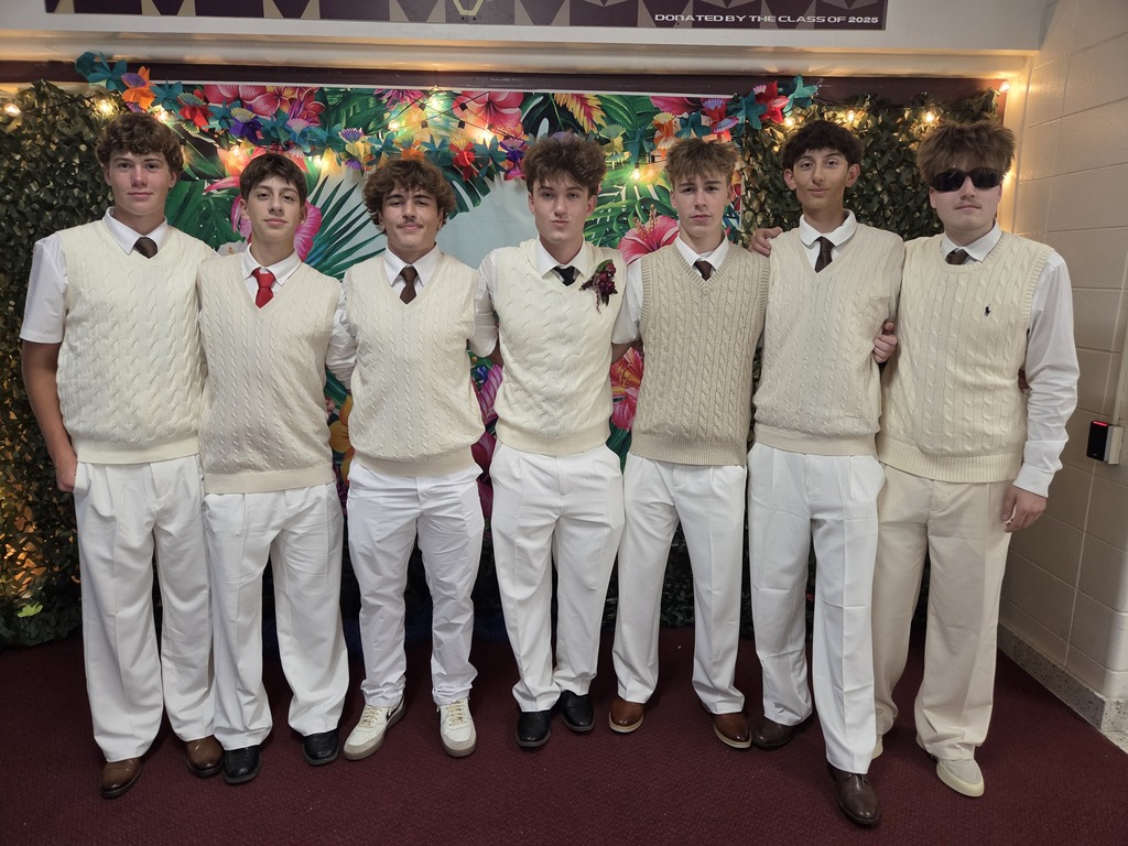 High school students all dressed in khaki pants and sweater vests.