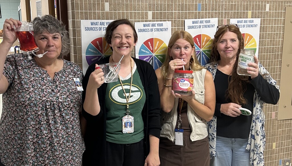 4 adults holding creative mugs.