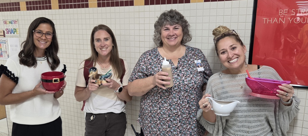 4 adults holding creative mugs.