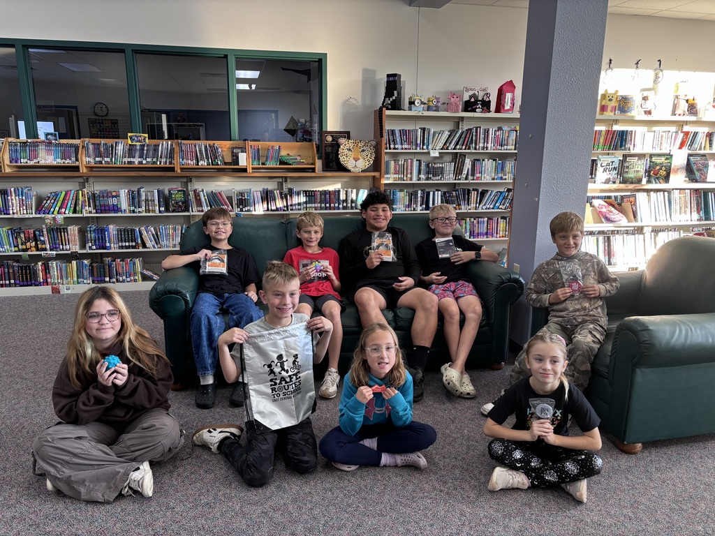 Nine elementary students holding prizes won through a drawing.