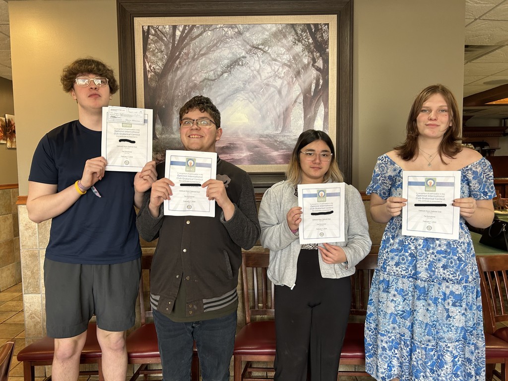 Four high school students standing next to each other holding a certificate in front of themselves.