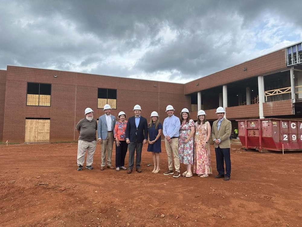 SC Attorney General, Alan Wilson shaking hands with SDPC Board Members, G2i Staff and Community Members with the G2i construction site in the background.