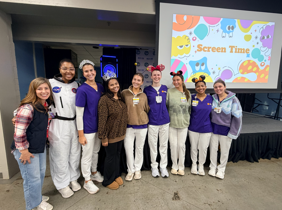 Clemson University Nursing Students that presented to our students are standing smiling in front of the stage where they spoke this morning 