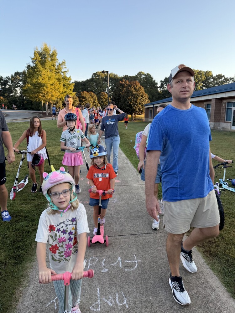 Students and parents scootering and walking to school