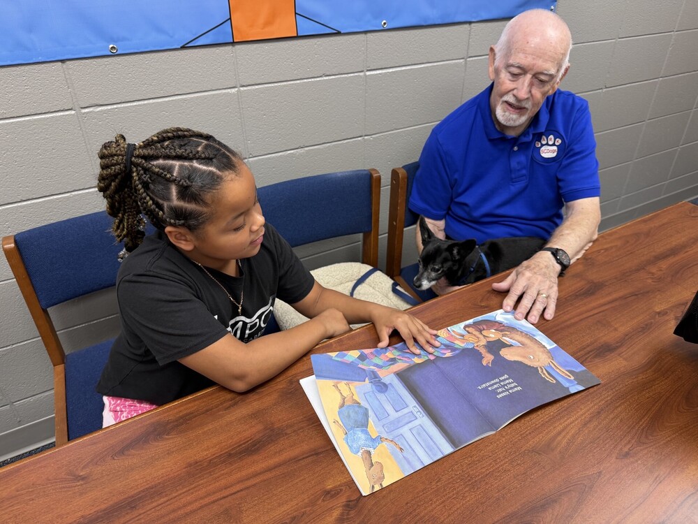 Student reading Llama Llama to Dabo and Mr. Jelinek.