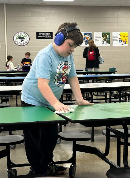 West End Elementary celebrates students demonstrating leadership. In one image, fifth grade student Levi Bolton wipes down cafeteria tables during lunch to help keep the space clean. 