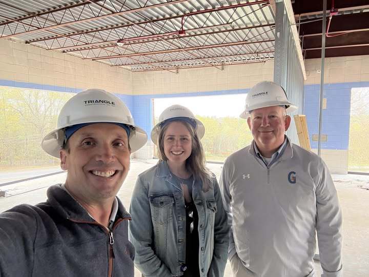 Tim Johnson stands with Hannah Smith and Ken Hitchcock inside the Gateway to Innovation (G2i) construction site, as they tour the space and observe the progress being made.