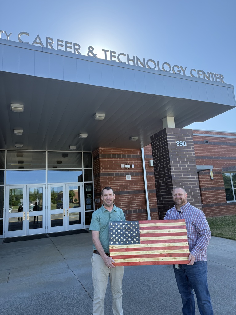 Kevin McCurry presents G2i Director Tim Johnson with a handmade wooden American flag for display at G2i.