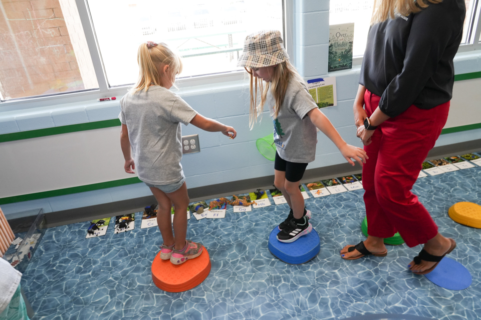 Grand Opening of SDPC Academy for Early Learners: students balancing on stepping stones in the "river"