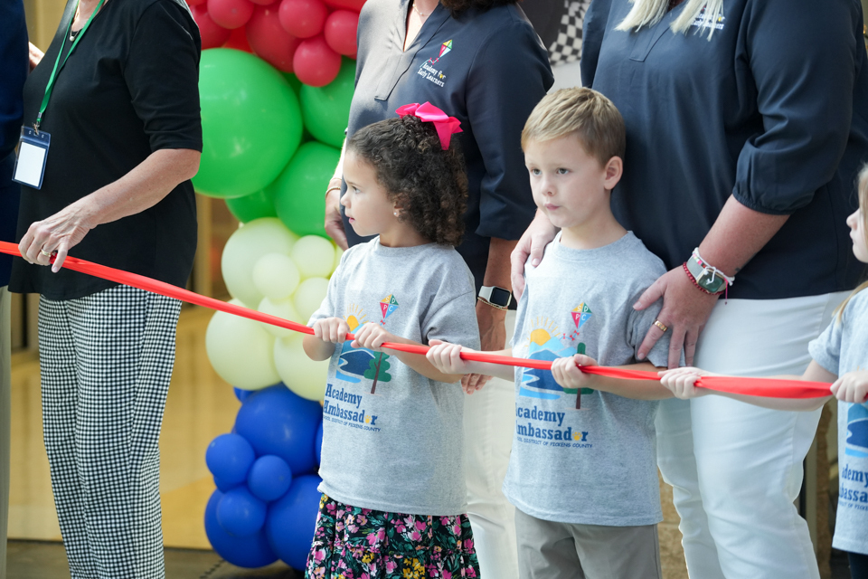 Grand Opening of SDPC Academy for Early Learners: students helping to hold ribbon during ribbon cutting