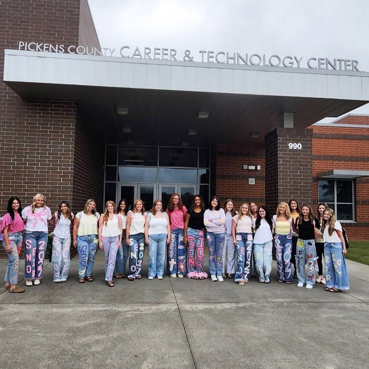 cosmetology students posing in front of career center, wearing their painted senior jeans
