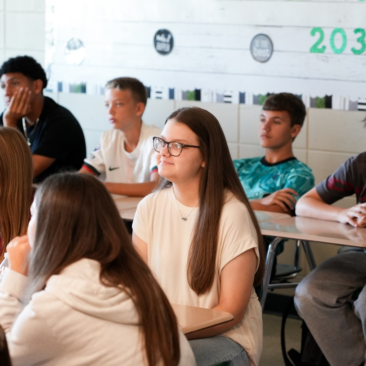 student smiling while listening in class