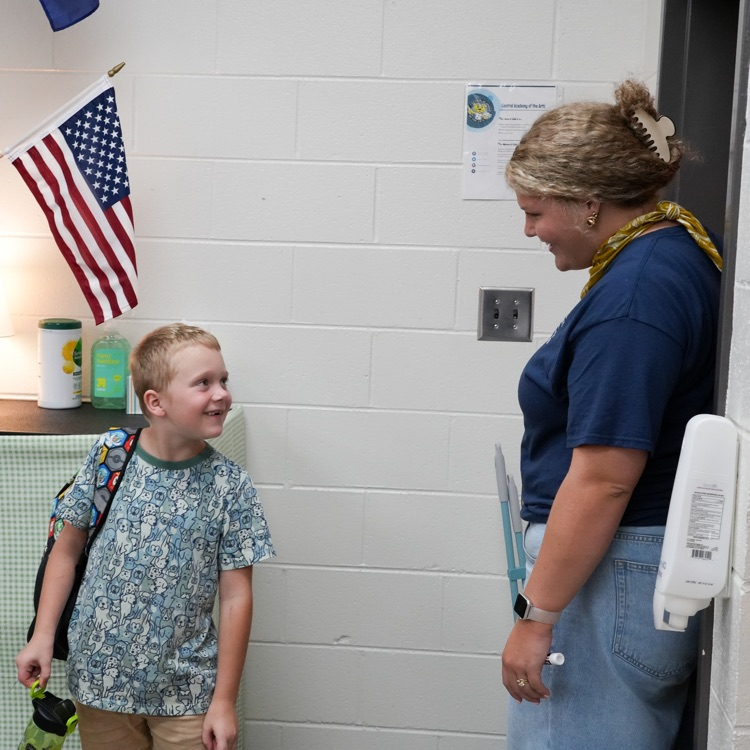 teacher welcoming student with a smile