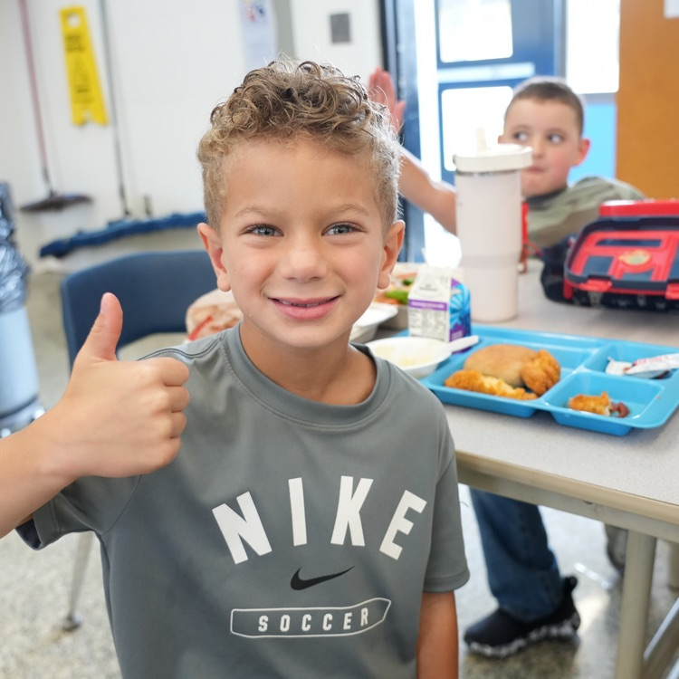 boy eating lunch, giving thumbs up