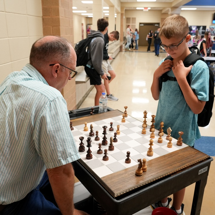 teacher playing chess with student at lunch