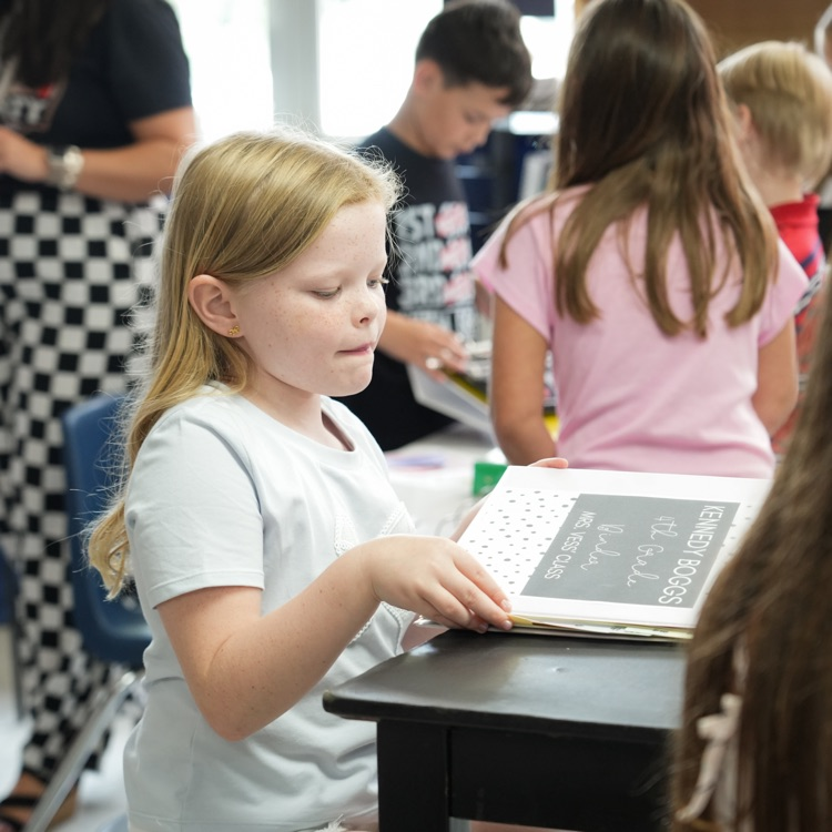student opening folder in classroom