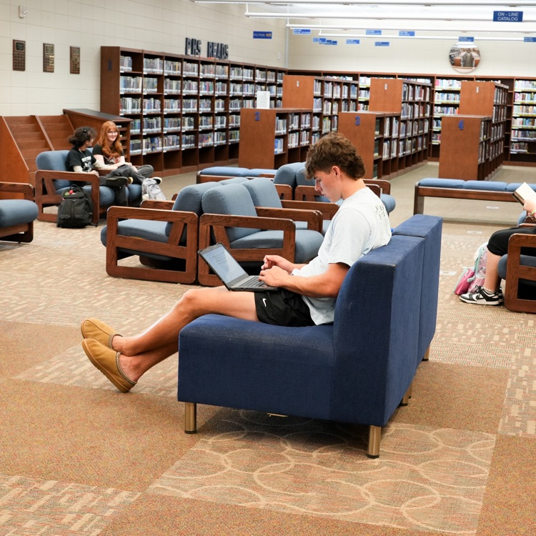 student working on laptop in library