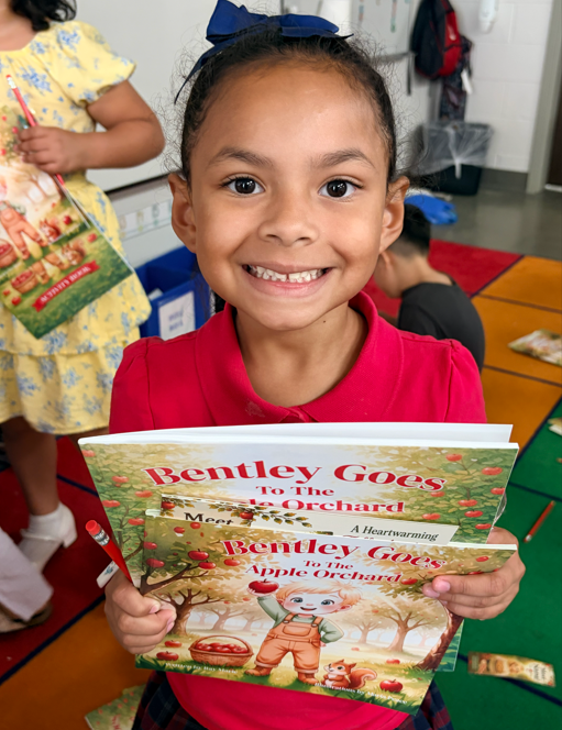 Children receiving books from guest Author with excitement