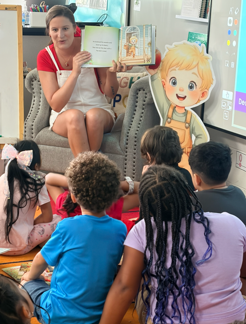 Children receiving books from guest Author with excitement