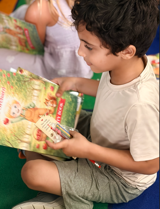 Children receiving books from guest Author with excitement