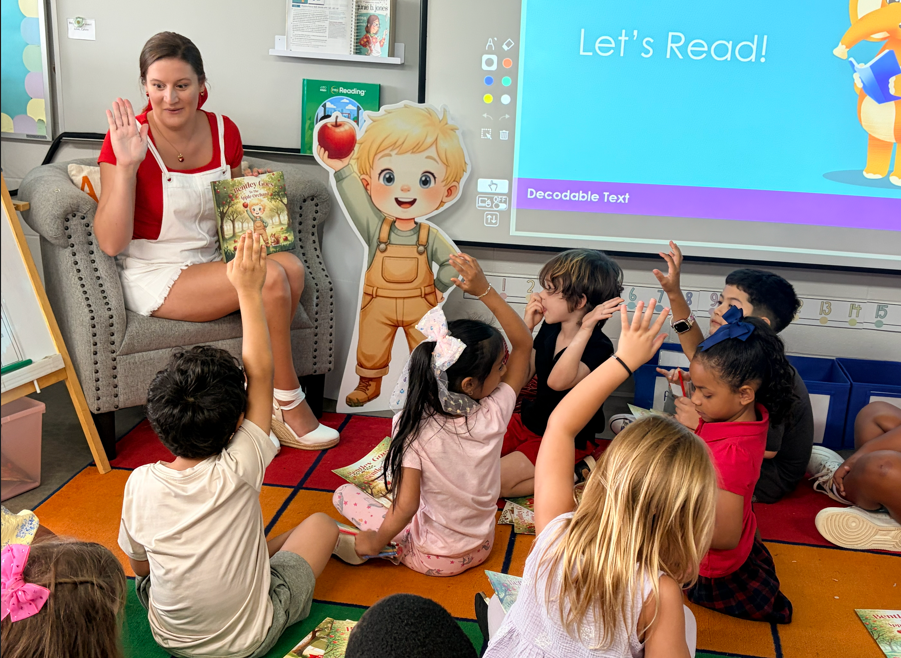 Children receiving books from guest Author with excitement