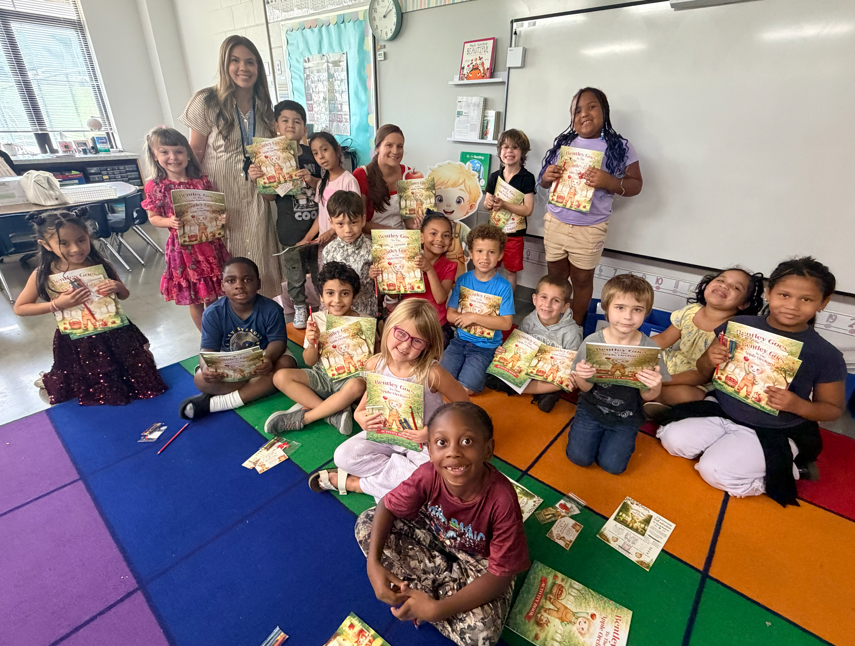 Children receiving books from guest Author with excitement